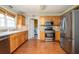 Well-lit kitchen featuring wood cabinets, stainless steel appliances, and hardwood floors at 1439 Evers Pl, Lawrenceville, GA 30043