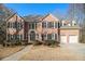 Traditional brick two-story home with black shutters, manicured landscaping, and attached two-car garage at 2050 Federal Rd, Roswell, GA 30075