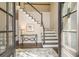 Inviting foyer with hardwood floors, staircase, elegant decor, and natural light streaming through the front door at 2050 Federal Rd, Roswell, GA 30075