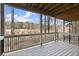 View from spacious rear deck with black iron railing overlooking a serene, wooded landscape at 8700 Mount Rushmore Dr, Alpharetta, GA 30022