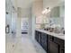 Bright bathroom with a double vanity, walk-in shower, and modern fixtures and white marble flooring at 3870 Ivy Cottage Dr, Snellville, GA 30039