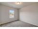 A bright bedroom has new gray carpeting and a single window at 3870 Ivy Cottage Dr, Snellville, GA 30039