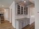 Butlers pantry with gray cabinets, granite countertop, and hardwood flooring at 3870 Ivy Cottage Dr, Snellville, GA 30039