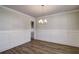 Dining area featuring wainscoting detail, modern chandelier, and hardwood floors at 3870 Ivy Cottage Dr, Snellville, GA 30039