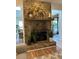 Close-up of a stone fireplace with a wooden mantel and decorative plants at 8740 Roswell Rd # 5G, Sandy Springs, GA 30350