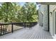 A gray wooden back deck with black railings overlooks a yard with tall green trees at 95 Lakeshore Ne Cir, Marietta, GA 30067