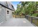 Gray wooden back deck with black railings and light gray home siding looks out on a lush green yard at 95 Lakeshore Ne Cir, Marietta, GA 30067