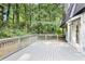 A back deck with gray wood and gray railings overlooks a lush backyard with tall trees at 95 Lakeshore Ne Cir, Marietta, GA 30067