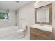 Bathroom featuring a rustic vanity, framed mirror, and tiled shower and tub at 95 Lakeshore Ne Cir, Marietta, GA 30067