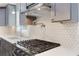 Close-up of a kitchen with a stainless steel range, quartz counters and stylish tile backsplash at 95 Lakeshore Ne Cir, Marietta, GA 30067