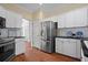 Modern kitchen with white cabinets, stainless steel appliances, and hardwood floors at , Woodstock, GA 30189