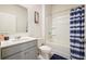 Well-lit bathroom featuring vanity with sink, a toilet, and shower with blue striped curtain at 288 Highgrove Way, Dallas, GA 30157