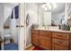 Bathroom with wooden cabinetry, sink, mirror, and an open door to an adjoining toilet at 3780 Clubview Se Ct, Conyers, GA 30094