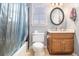 Bathroom featuring a wood vanity, large mirror, and a shower with a blue curtain at 3780 Clubview Se Ct, Conyers, GA 30094