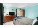 Bright bedroom featuring a bed, dresser with television, wardrobe, and cheerful blue walls at 3780 Clubview Se Ct, Conyers, GA 30094