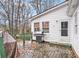 View of home's wooden deck with grill and covered furniture, surrounded by wooded landscape at 3780 Clubview Se Ct, Conyers, GA 30094