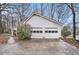 The two-car garage features white doors and is surrounded by mature trees at 3780 Clubview Se Ct, Conyers, GA 30094