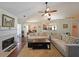 Cozy living room with a fireplace, hardwood floors, ceiling fan, and plush sofas at 942 Fairmont Park Dr, Dacula, GA 30019