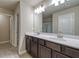 Bathroom featuring a double sink vanity with espresso cabinets, an oversized mirror and wood look flooring at 4604 Eastbrook Pl, Snellville, GA 30039