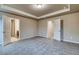 Bedroom featuring a tray ceiling, neutral walls, carpet, and multiple doorways at 4604 Eastbrook Pl, Snellville, GA 30039