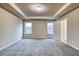 Bedroom featuring a tray ceiling, neutral walls, carpet, and two windows at 4604 Eastbrook Pl, Snellville, GA 30039