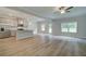 Open-concept living room boasts luxury vinyl plank flooring and neutral-toned kitchen with stainless appliances at 4604 Eastbrook Pl, Snellville, GA 30039