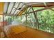 Large screened-in back porch with wood flooring and view of the surrounding trees at 6464 Westerly Way, Douglasville, GA 30135