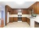 Functional kitchen with wooden cabinetry, white appliances and ample counter space at 6464 Westerly Way, Douglasville, GA 30135