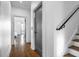 Hallway with dark hardwood flooring, leading to doorway and staircase with black metal railing at 77 Krog Ne St, Atlanta, GA 30307