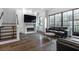 Open-concept living room with modern fireplace, dark wood floors, and doors to outdoor space at 77 Krog Ne St, Atlanta, GA 30307