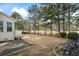 View of the backyard with patio surrounded by landscaped yard and mature trees at 9620 Coastal Pointe Dr, Villa Rica, GA 30180