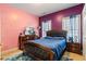 Eclectic bedroom featuring pink and purple walls, dresser and a bed with dark wooden trim at 9620 Coastal Pointe Dr, Villa Rica, GA 30180