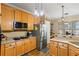 Well lit kitchen area with honey colored cabinets, and stainless steel appliances and fixtures at 9620 Coastal Pointe Dr, Villa Rica, GA 30180