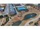 Aerial view of the community featuring townhomes, a pond, and a tennis court at 112 Calder Dr, Alpharetta, GA 30009