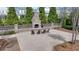 Outdoor fireplace features a brick surround, seating, and mature trees at 112 Calder Dr, Alpharetta, GA 30009