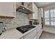 Close up of kitchen with stainless steel hood, subway tile backsplash and gas range at 112 Calder Dr, Alpharetta, GA 30009