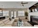 Bright living room featuring hardwood floors, a ceiling fan, and a modern fireplace with large, comfortable white seating at 112 Calder Dr, Alpharetta, GA 30009