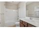 Bright bathroom featuring a shower-tub combination and single sink vanity with brown cabinets at 2471 Arnold Palmer Way, Duluth, GA 30096