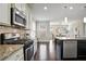 Well-equipped kitchen featuring a gas range, stainless steel appliances, granite counters, and a view to the dining area at 2471 Arnold Palmer Way, Duluth, GA 30096