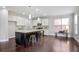 Bright kitchen featuring a dark island, hardwood floors, stainless steel appliances, and white cabinets at 2471 Arnold Palmer Way, Duluth, GA 30096