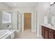 Main bathroom featuring a walk-in shower, soaking tub, and view to the walk-in closet at 2471 Arnold Palmer Way, Duluth, GA 30096