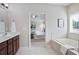 Main bathroom with soaking tub, view to the main bedroom, and double sink vanity at 2471 Arnold Palmer Way, Duluth, GA 30096