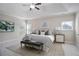 This main bedroom features a tray ceiling, ceiling fan, neutral walls, and natural light at 2471 Arnold Palmer Way, Duluth, GA 30096