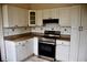 Functional kitchen with white cabinets, black appliances, and tiled backsplash at 2642 Joyce Ave, Decatur, GA 30032