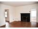 Inviting living room with hardwood floors, a fireplace, and natural light through doorway and window at 2642 Joyce Ave, Decatur, GA 30032