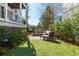 Landscaped backyard featuring a stone patio with outdoor seating, lush lawn, and manicured greenery at 385 Rowes Cir, Alpharetta, GA 30009