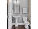 Elegant half bathroom with pedestal sink, decorative mirror, and modern fixtures at 385 Rowes Cir, Alpharetta, GA 30009