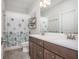 Well-lit bathroom featuring a double vanity, tile floors, and a shower with a stylish curtain at 385 Rowes Cir, Alpharetta, GA 30009