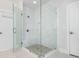 Modern glass-enclosed shower, stone flooring, and a built-in shower seat at 385 Rowes Cir, Alpharetta, GA 30009