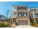 Beautiful home featuring a two-car garage, a covered front porch, second-story balcony, and manicured landscaping at 385 Rowes Cir, Alpharetta, GA 30009